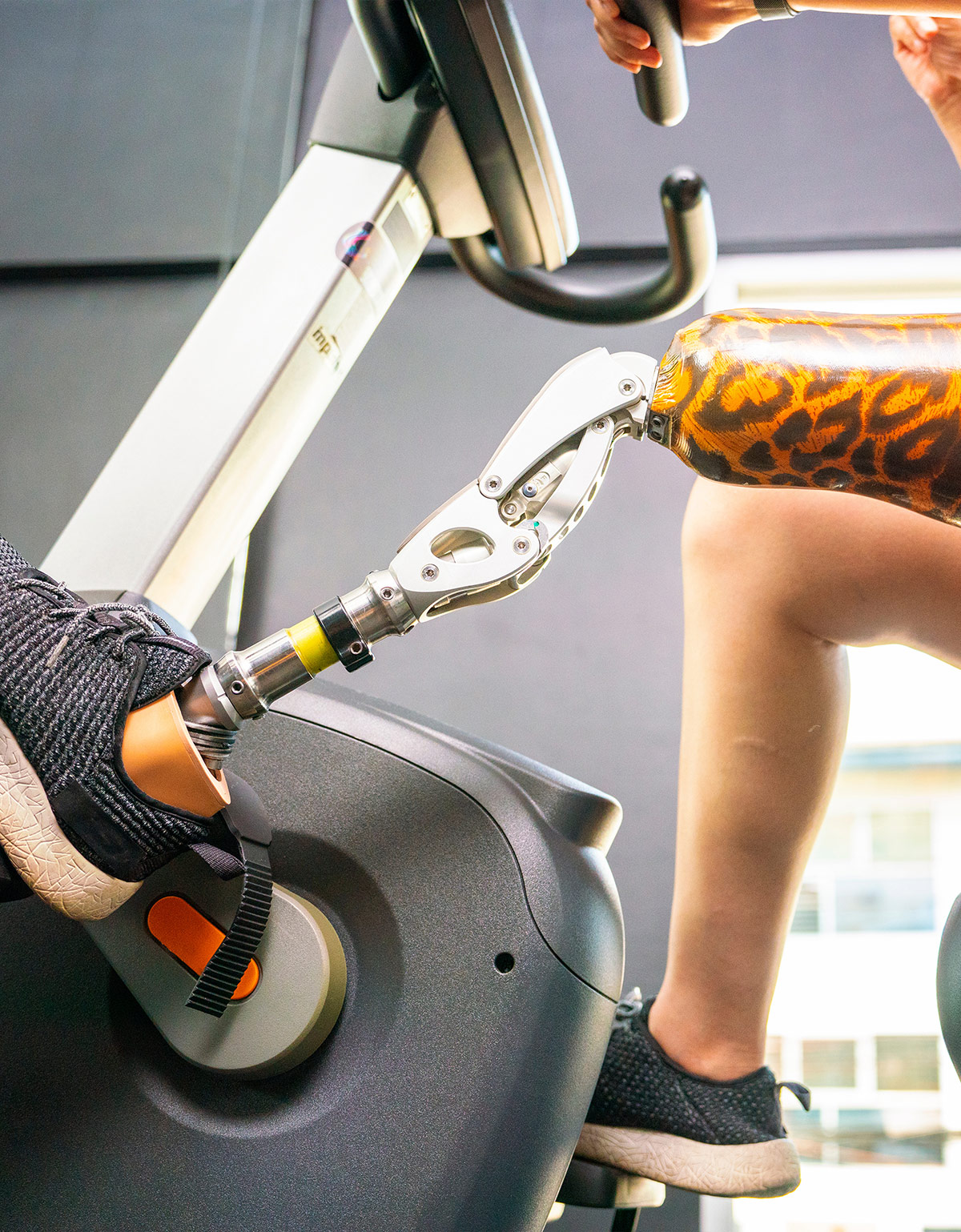 Foto einer Frau mit einer Prothese auf einem Ergometer